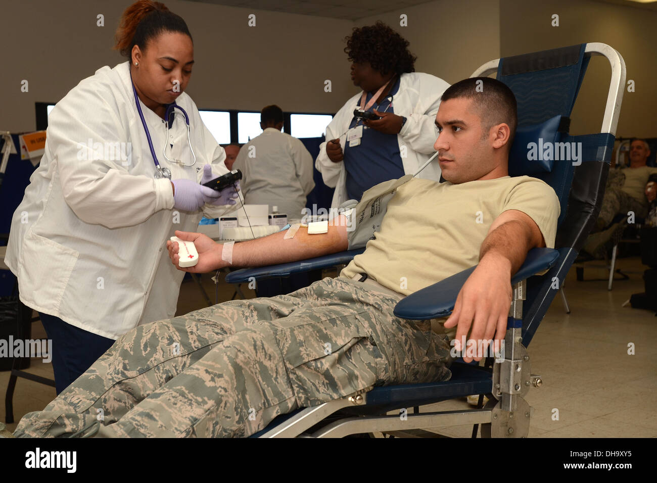 Nicola Weston, with the American Red Cross, uses a handheld to verify the bloodbag matches the donor as U.S. Air Force Senior Airman Lucas Mastrangelo gives blood during the on-base blood drive at McEntire Joint National Guard Base of the South Carolina A Stock Photo