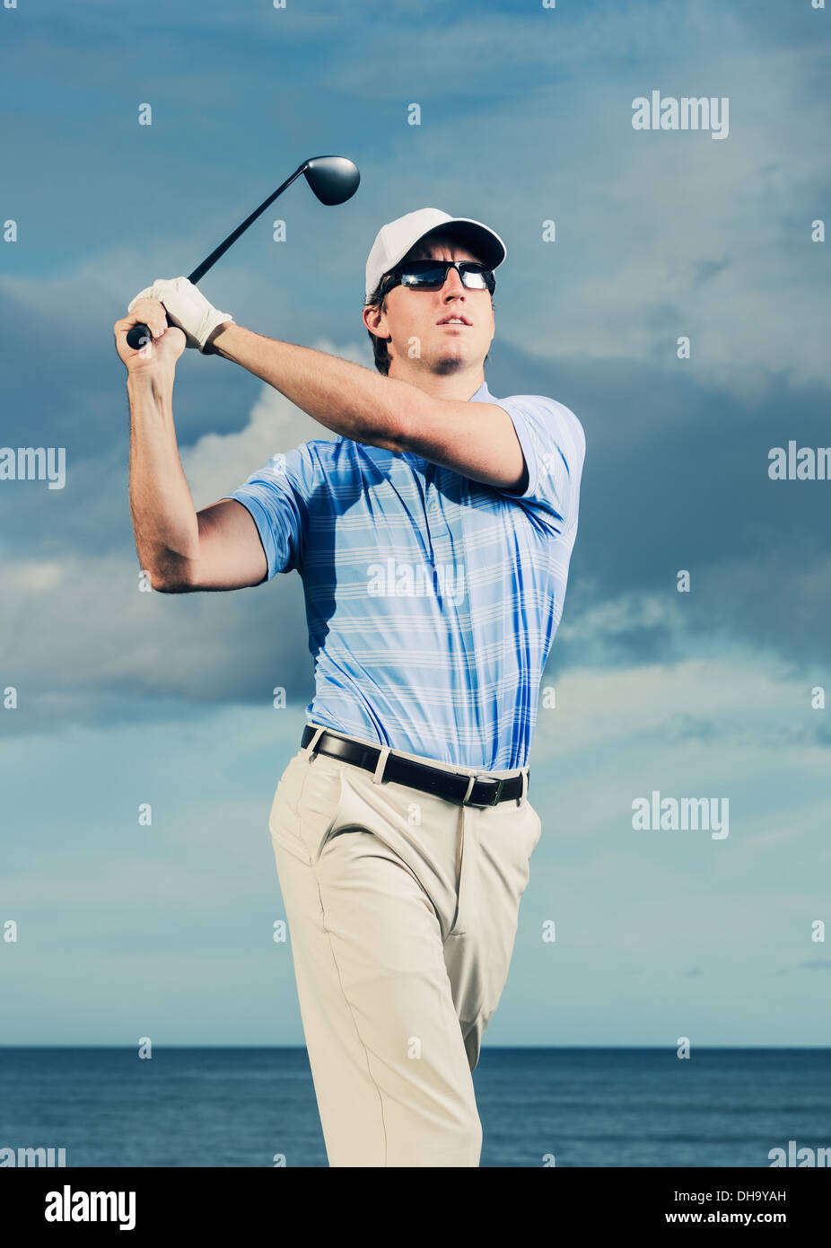 Golfer At Sunset Man Swinging Golf Club With Dramatic Blue