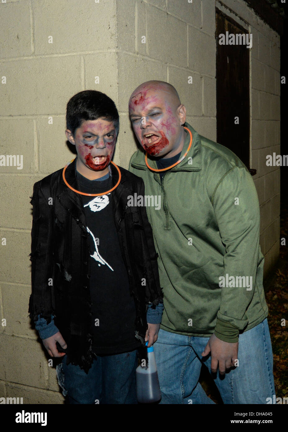 Zombie 'get ya's' Tech Sgt. Jacob Elliot, 48th Fighter Wing foreign object damage monitor, and his 11-year-old son, Boston Elliot, scowl before chasing participants of the Halloween Zombie Run at the base track on Royal Air Force Lakenheath, England, Oct. Stock Photo