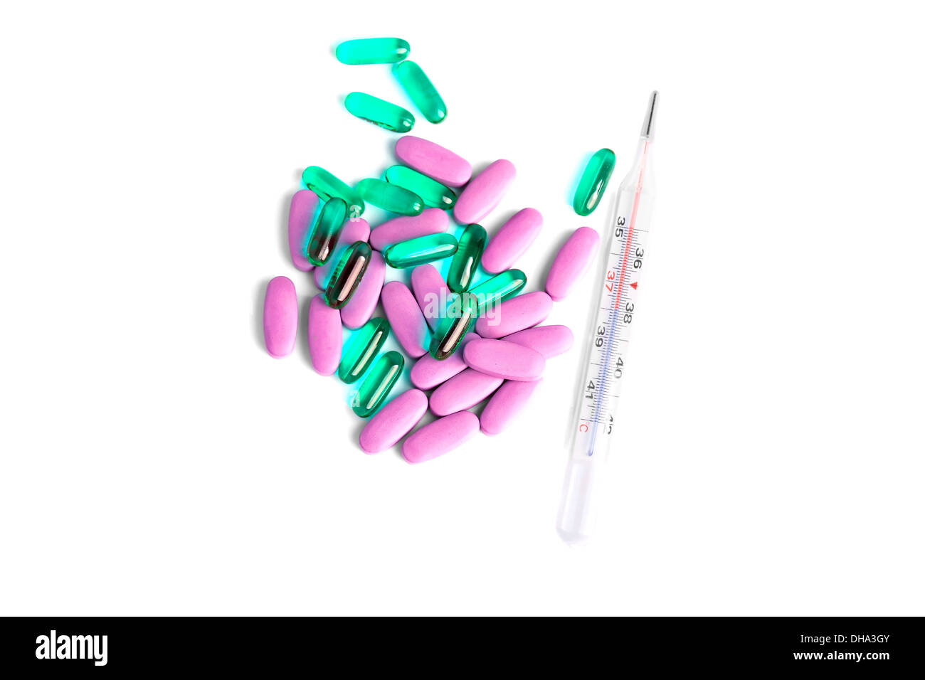 Thermometer and a heap of luminicent and regular pills as cure concept Stock Photo