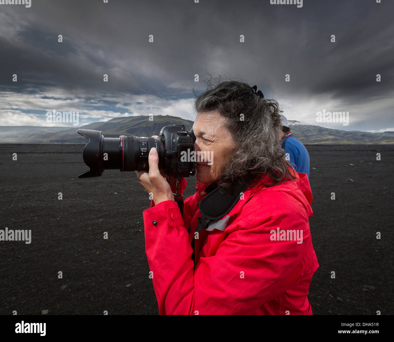 Woman takiing a picture using a DSLR camera, Thorsmork, Iceland Stock Photo