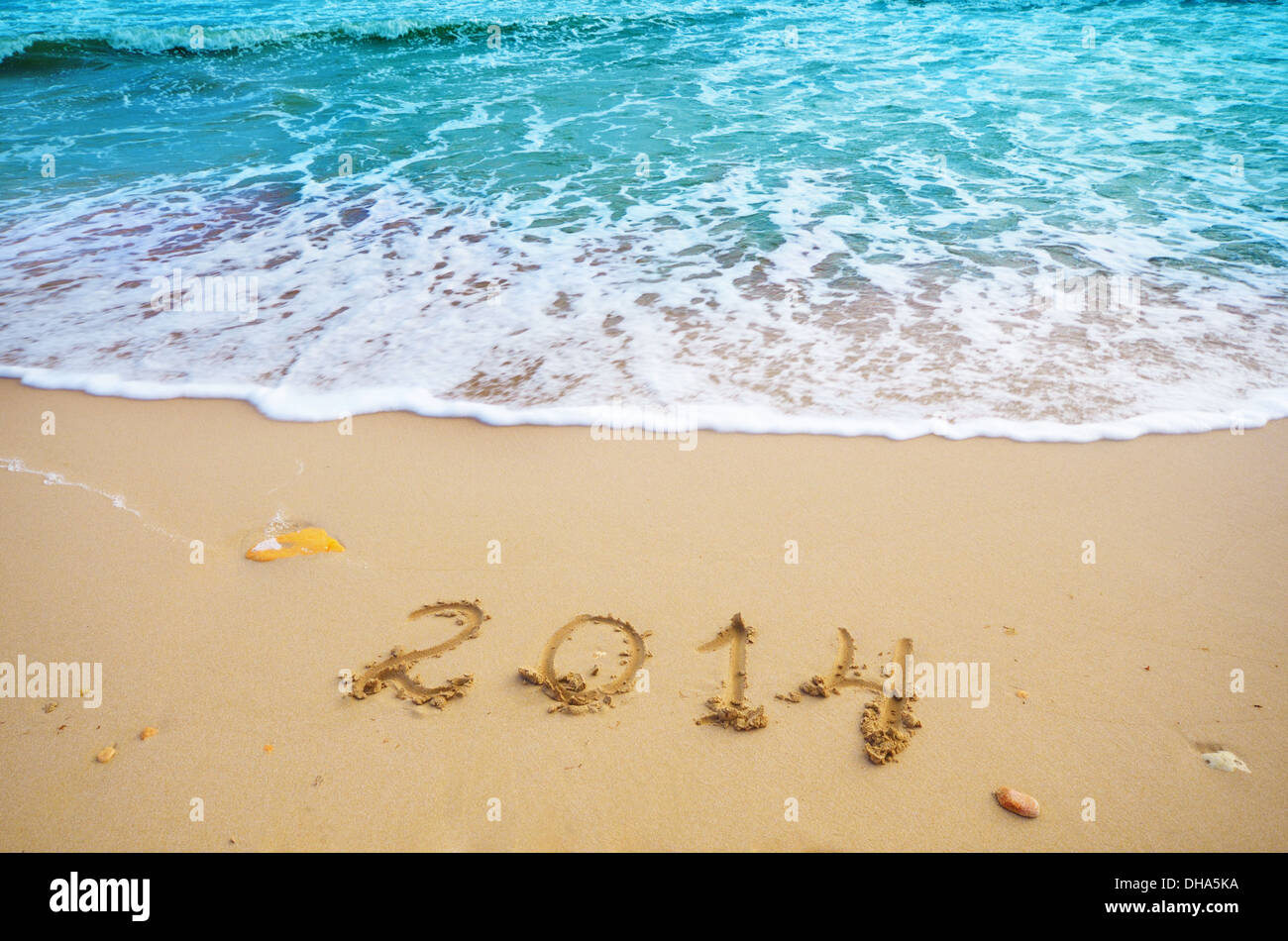 Year 2014 coming concept on beach sand, the wave is washing digits Stock Photo