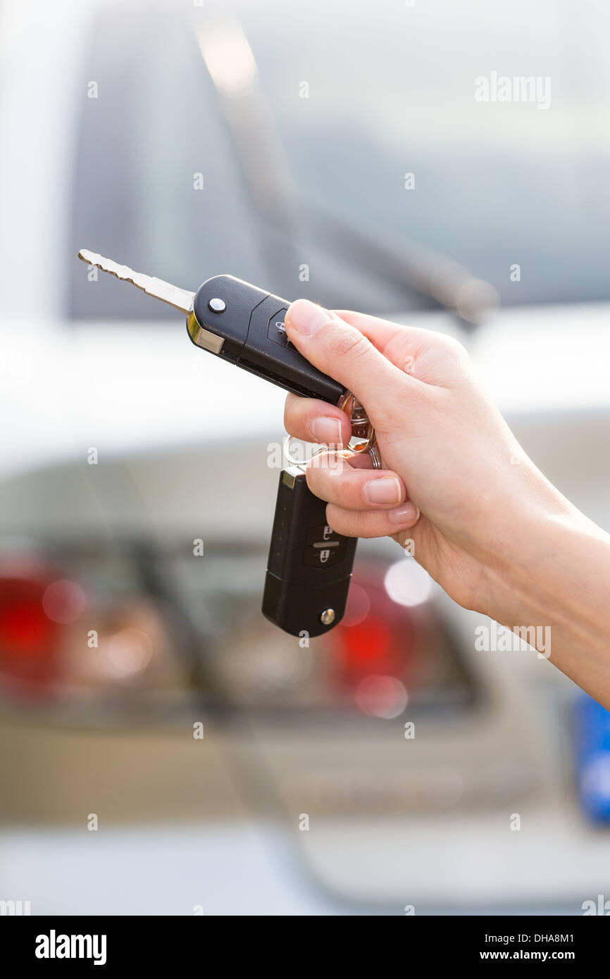 women's hand presses on the remote control car alarm systems Stock Photo