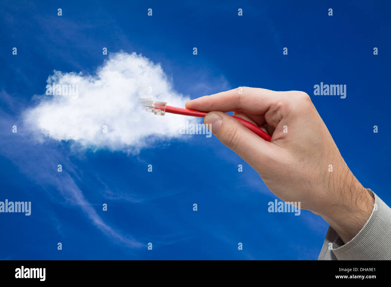 Cloud computing concept. Hand with ethernet cable connecting into cloud. Stock Photo