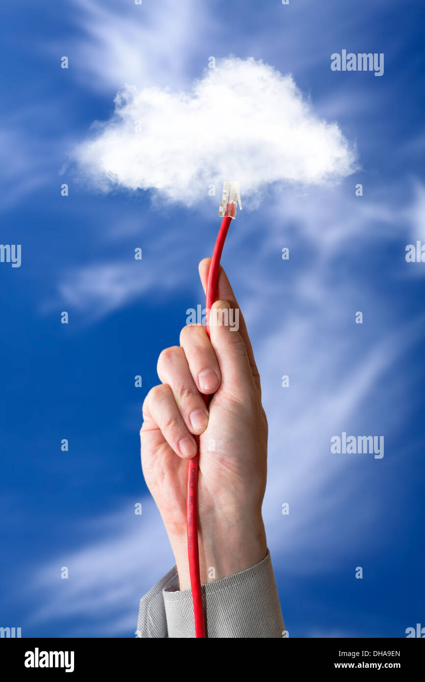 Cloud computing concept. Hand with ethernet cable connecting into cloud. Stock Photo