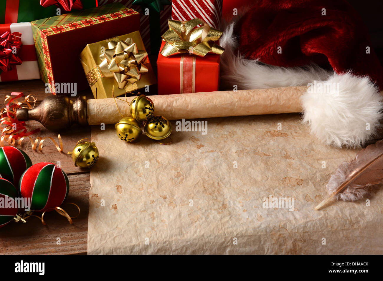 A Christmas Still Life with an old parchment scroll, presents, ornaments and a Santa Hat. Stock Photo