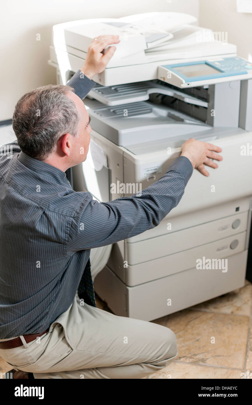 Business man opening photocopy machine in office Stock Photo