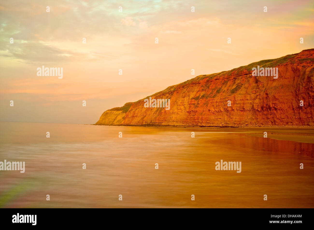 A headland against a golden, coastal sunset. Stock Photo