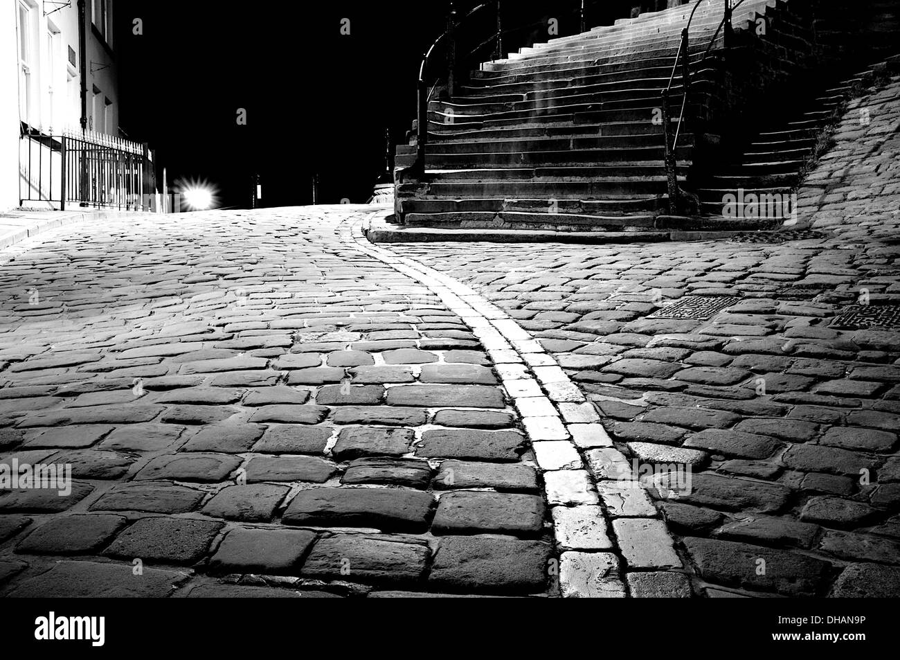 Black And White Low Angle Shot Of A Cobbled Street With A Stone