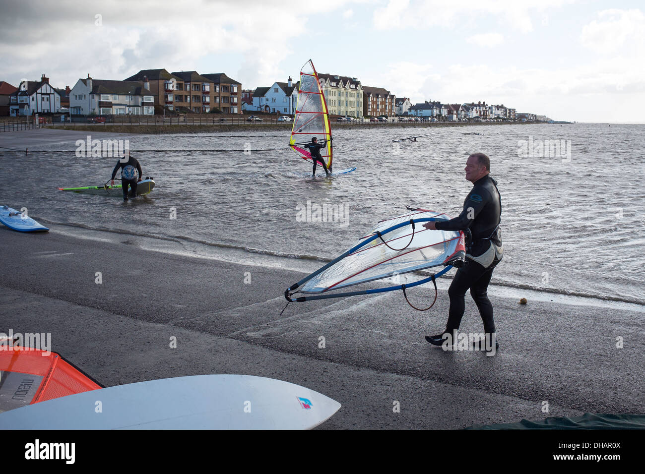 People windsurfing on the Marine Lake at West Kirby on the Wirral on a very cold blustery day Stock Photo