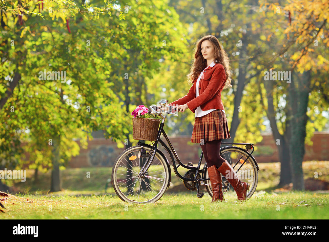 Young female walking with bicycle in park Stock Photo