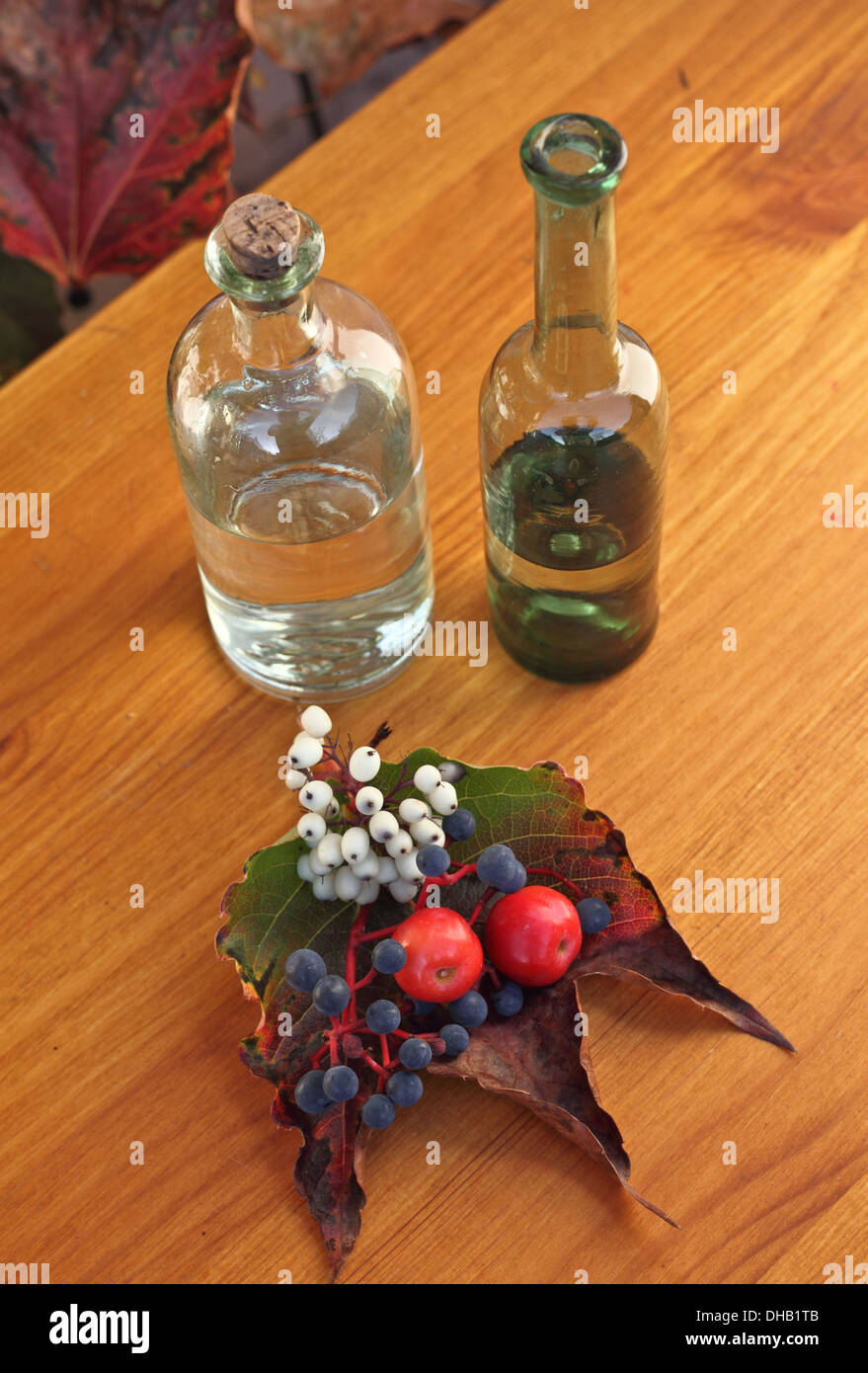 Two vintage bottles, blueberry and two small red apples on table Stock Photo