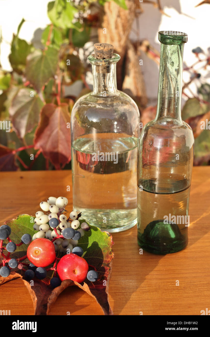 Two vintage bottles, blueberry and two small red apples on table Stock Photo
