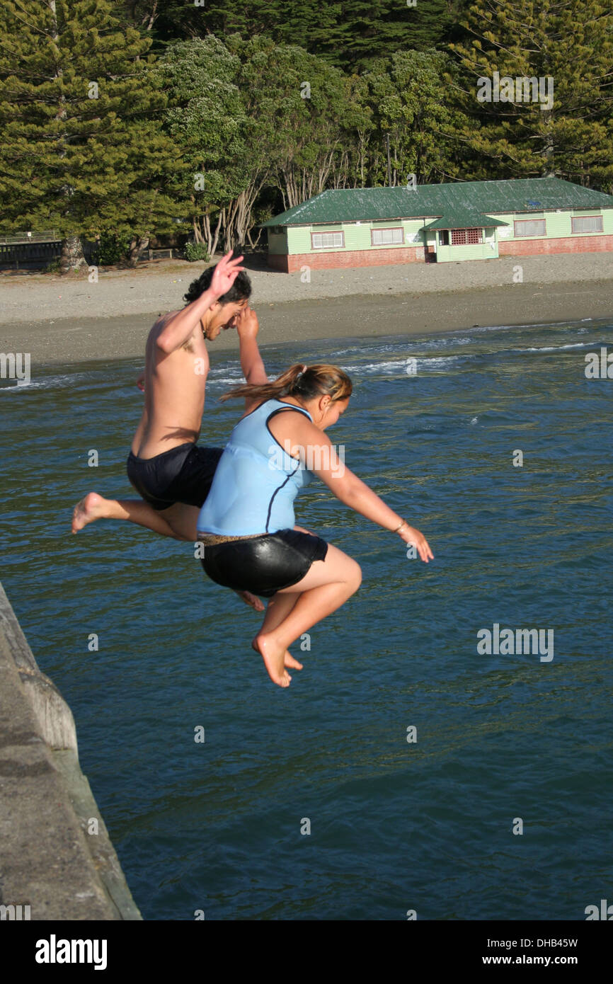 Boy and girl jumping off pier into the water Stock Photo Alamy
