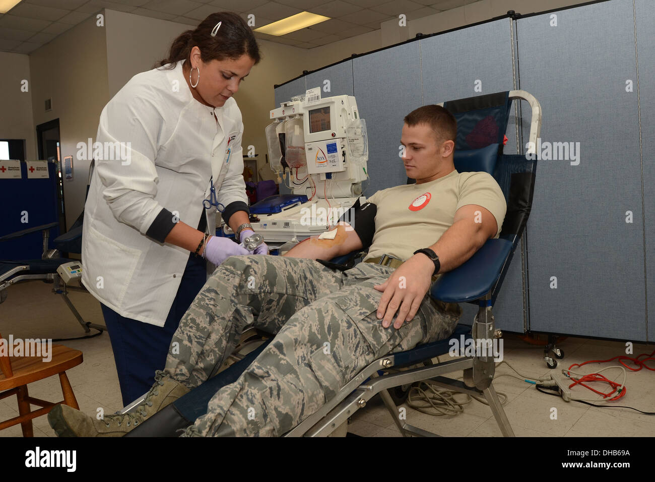Kay Arroyo with the American Red Cross removes the tubes from the arm of U.S. Air Force Staff Sgt. Tyler Kellogg during the on-base blood drive at McEntire Joint National Guard Base of the South Carolina Air National Guard, Nov. 3, 2013. Kellogg, a fire t Stock Photo