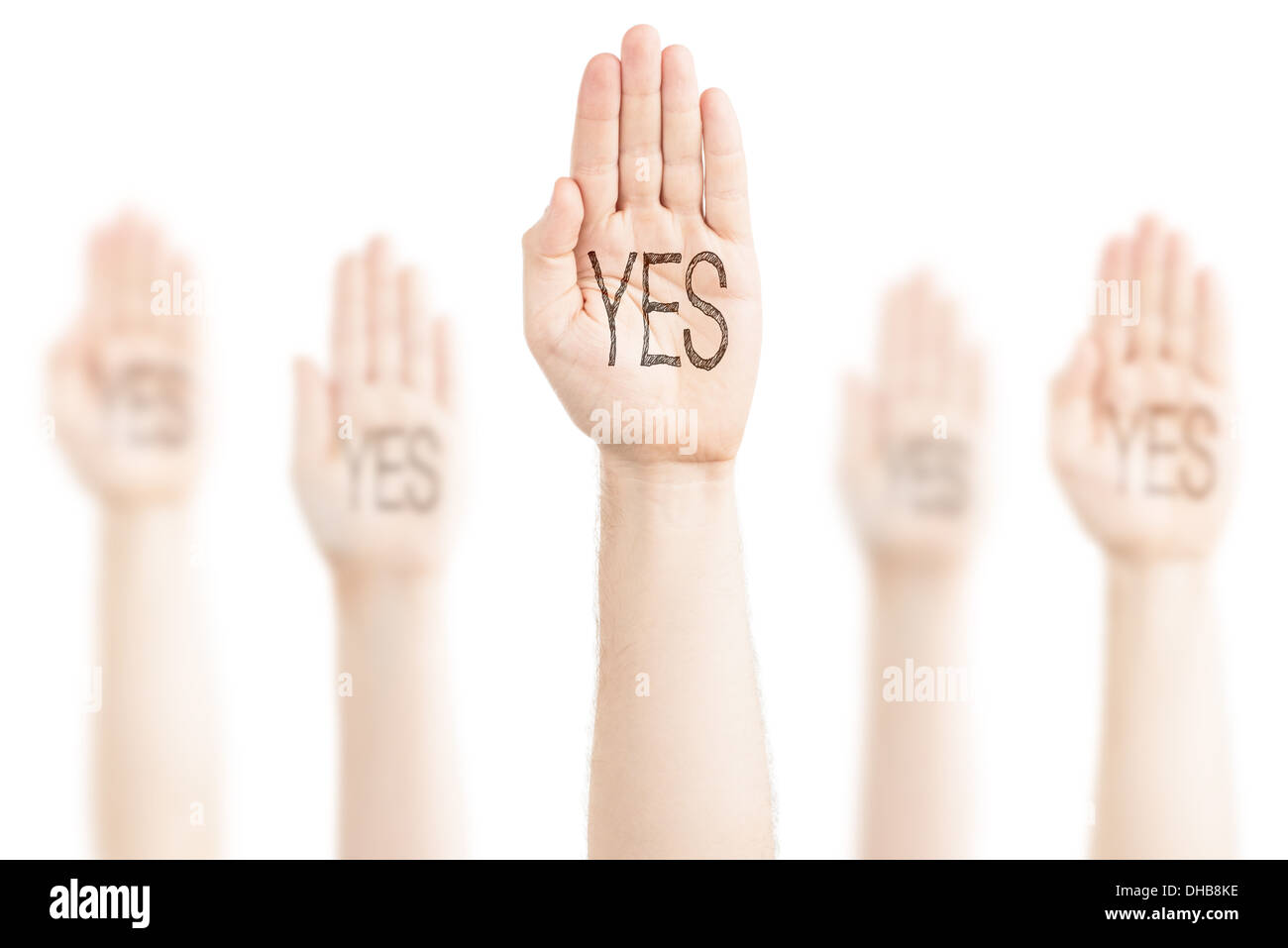 Hands raised to the sky on a white background, expression of consent. On the palms there is an inscription — 'Yes'. Stock Photo