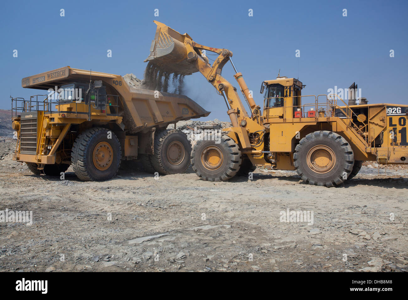 Action shot of a front end loader filling a large haul dump mine Stock