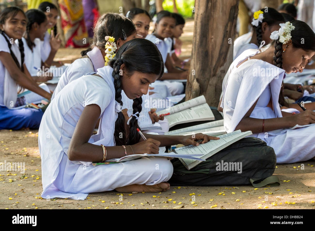 Rural Indian village high school girls writing in books in an outside class. Andhra Pradesh, India Stock Photo