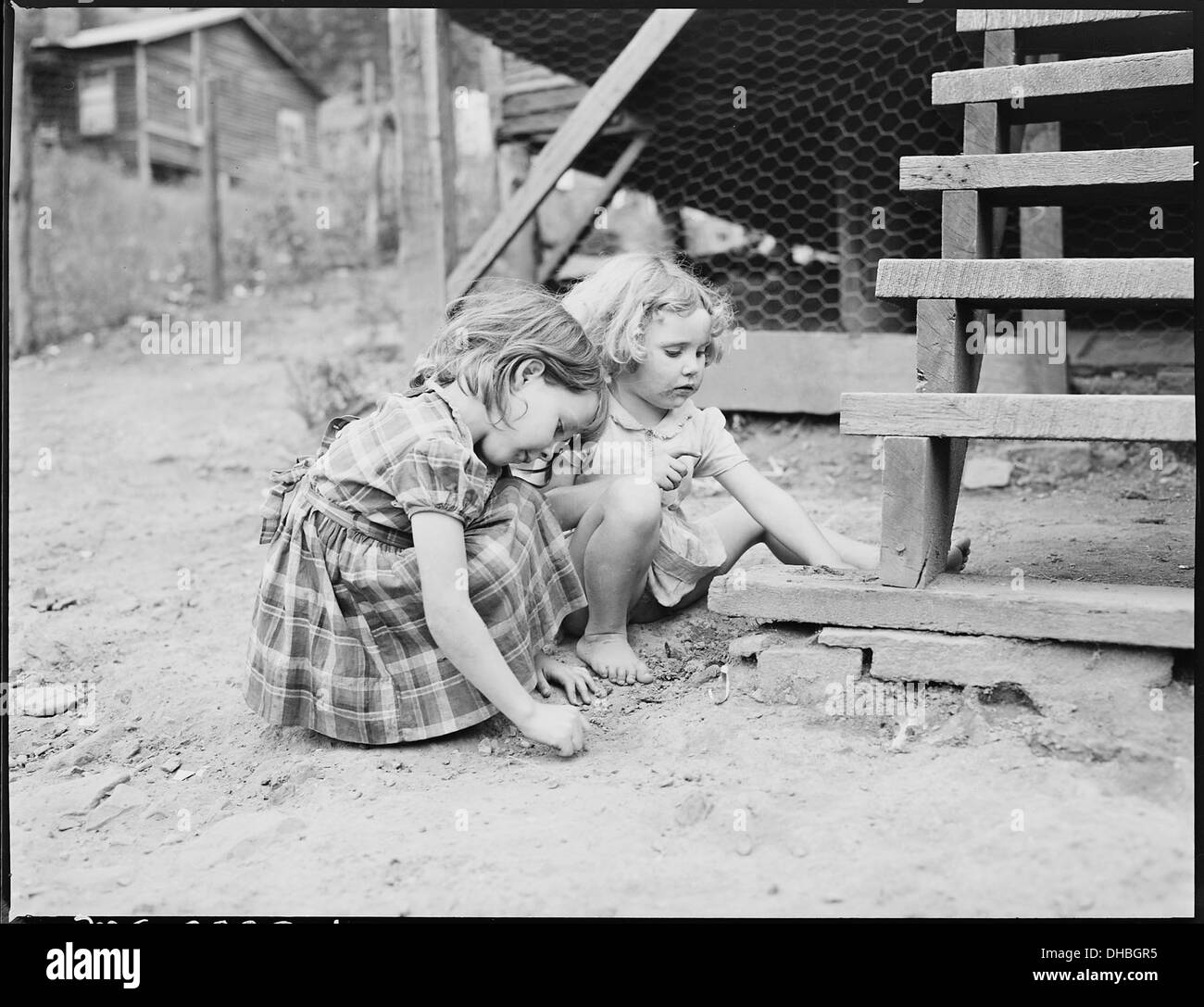 Bobbie Jean, right, playing near her front steps with a friend. P V & K Coal Company, Clover Gap Mine, Lejunior... 541379 Stock Photo