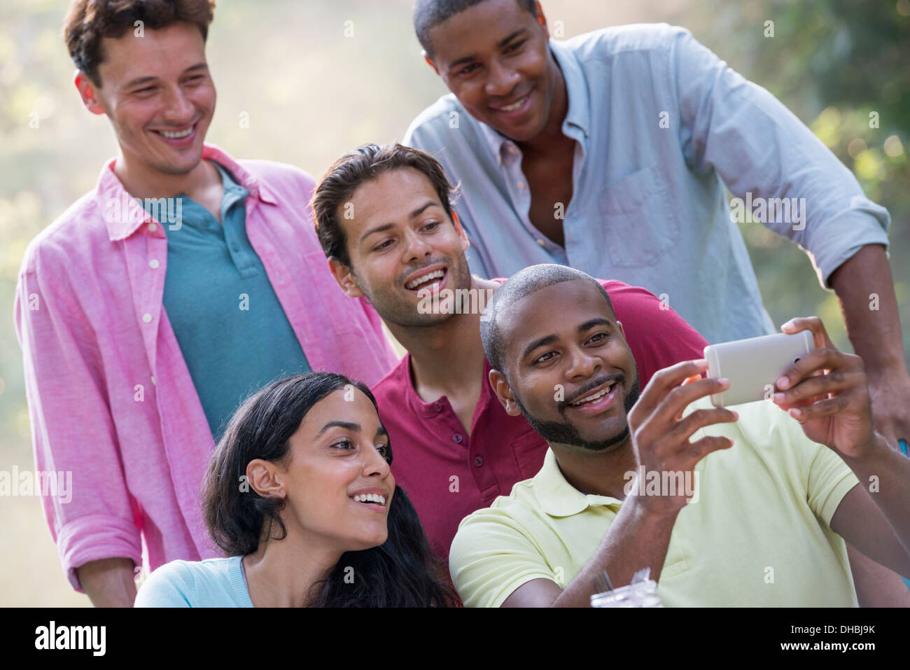 A group of people having a meal outdoors, a picnic. Men and women. Stock Photo