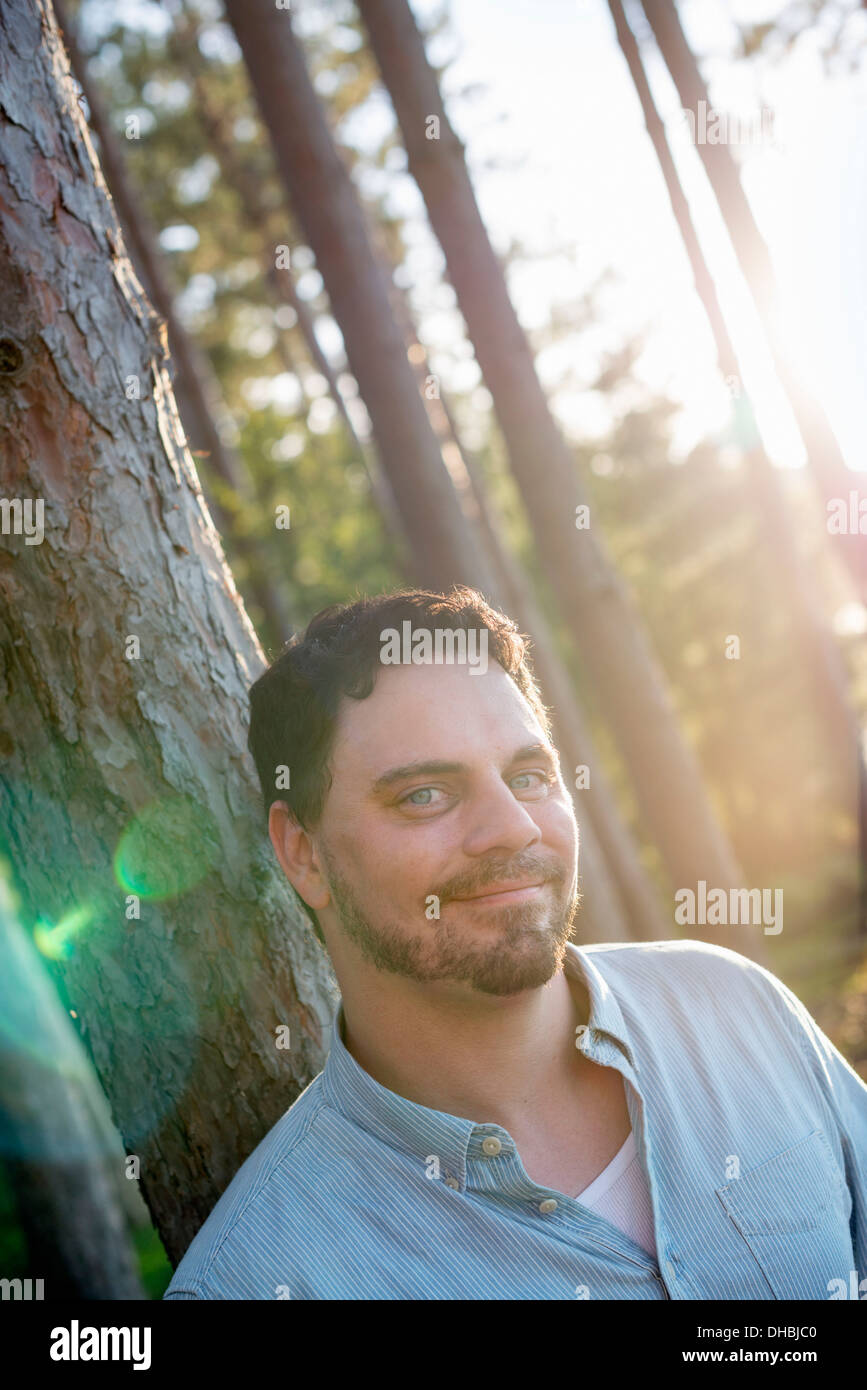 A man standing in woodland by a lake Stock Photo - Alamy