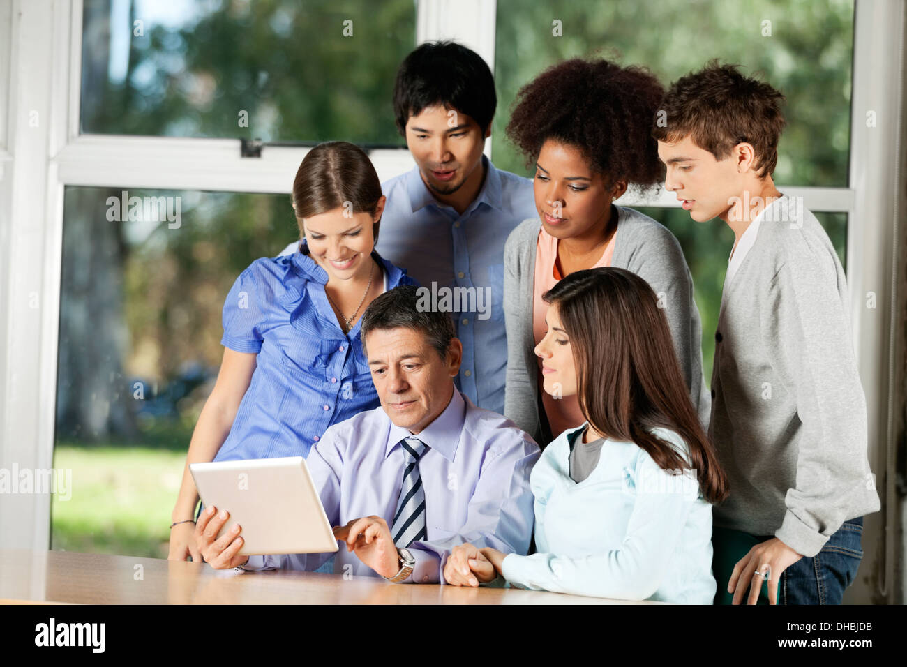Teacher Using Digital Tablet While Students Standing Around Him Stock ...