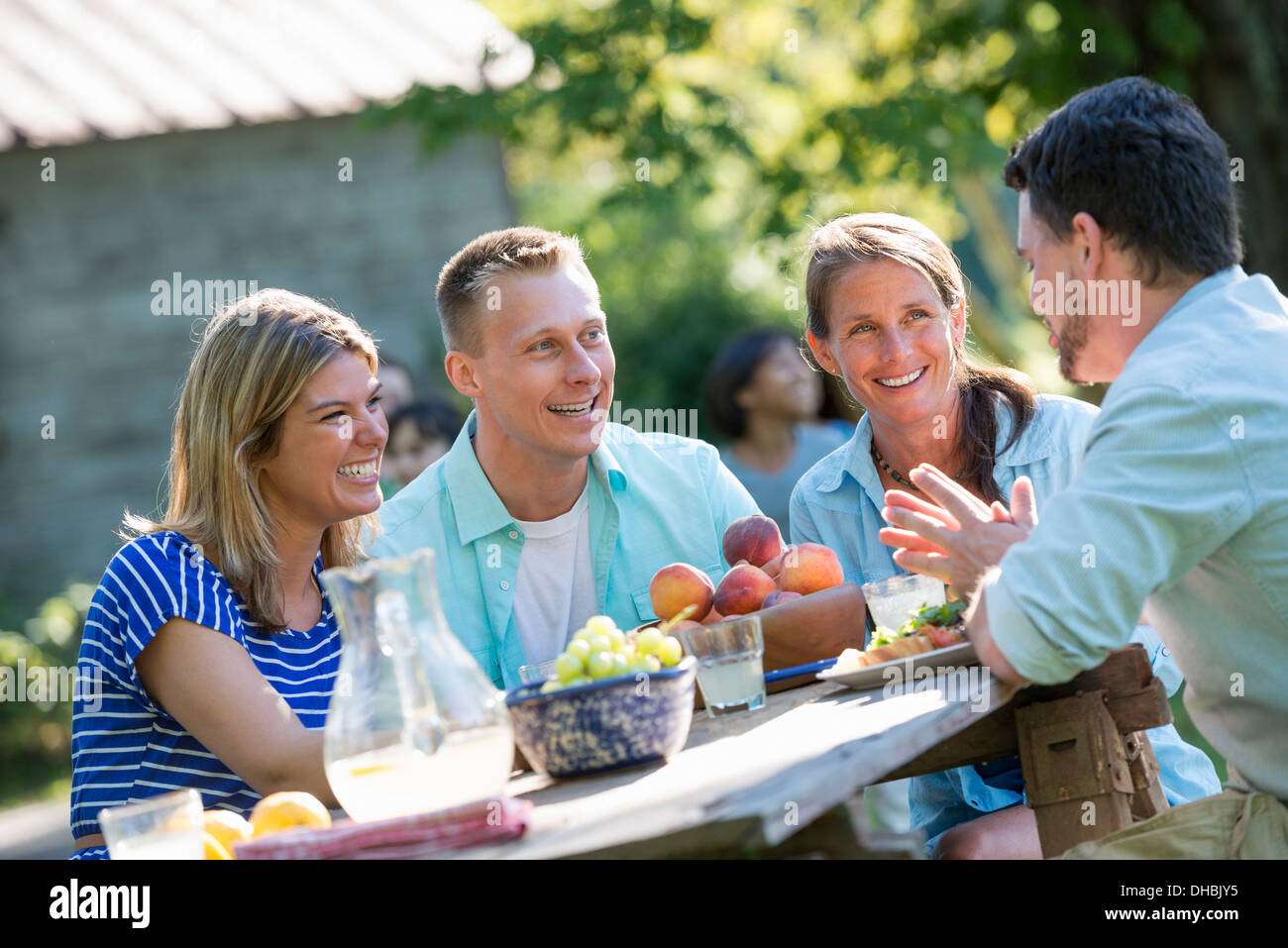 A family, adults and children seated around a table, enjoying a meal together. Stock Photo