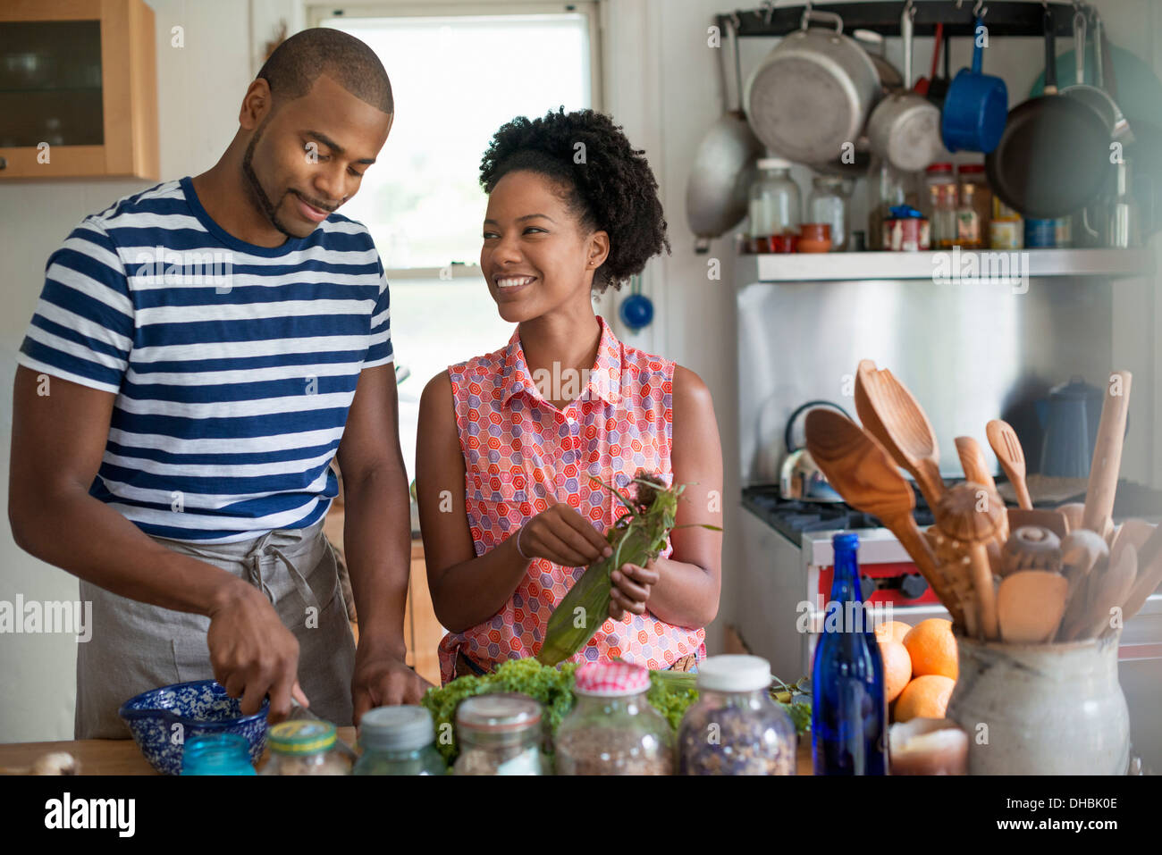 Lifestyle. Two people working in a farmhouse kitchen. Stock Photo