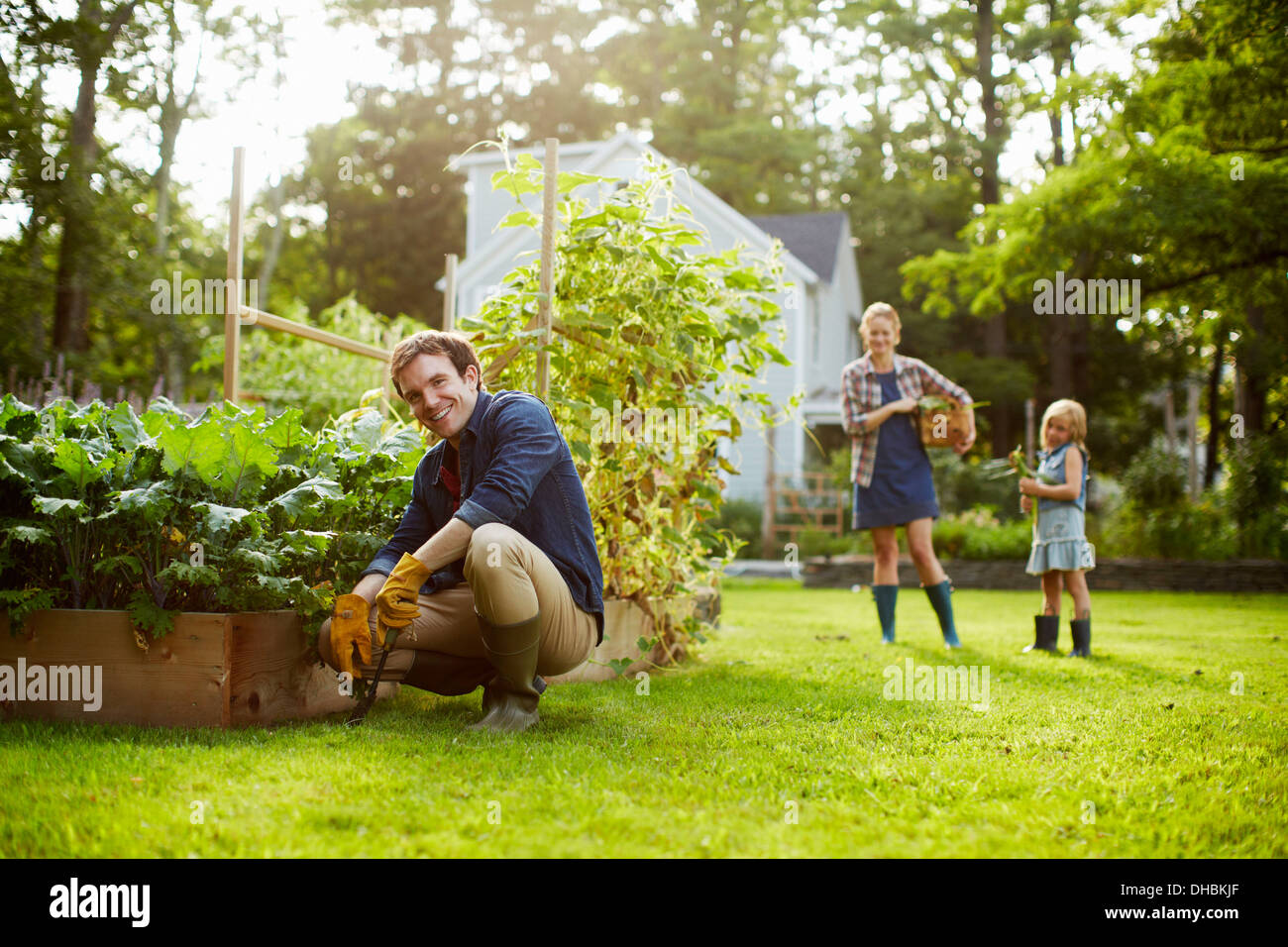 Three people, two adults and a child in a vegetable garden. Stock Photo