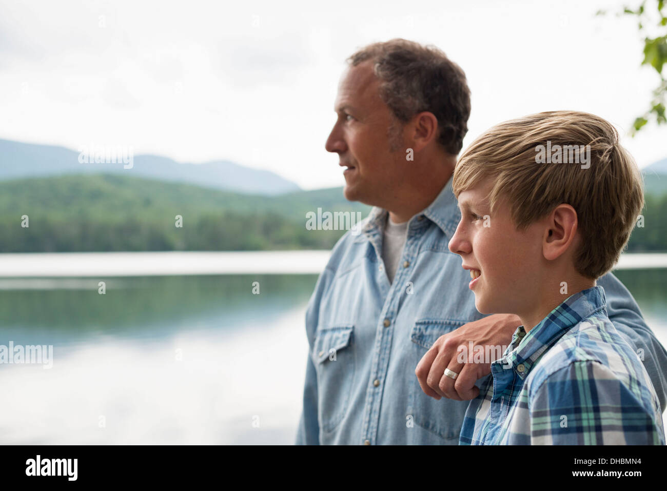A family outdoors under the trees on a lake shore. Father and son. Stock Photo