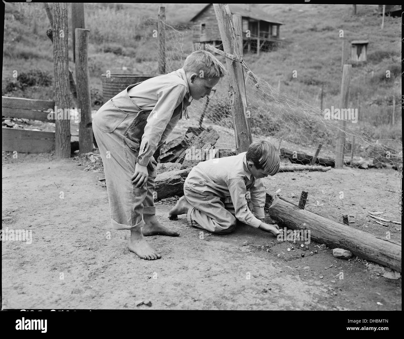 Donald Sergent shooting marbles while a pal looks on. P V & K Coal Company, Clover Gap Mine, Lejunior, Harlan County... 541352 Stock Photo