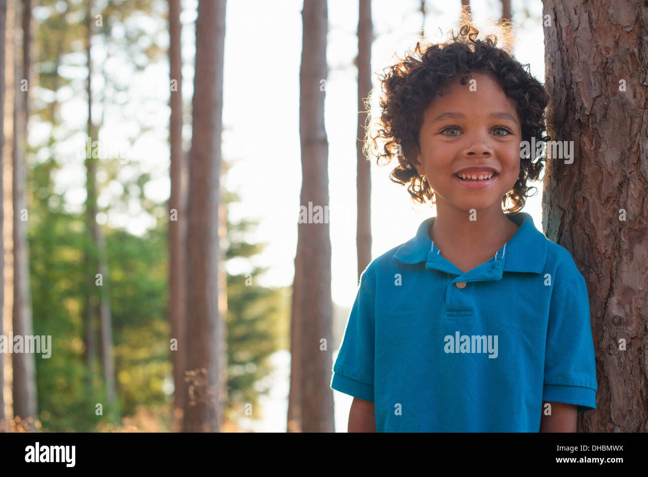 Trees on the shores of a lake. A child standing among the trees. Stock Photo