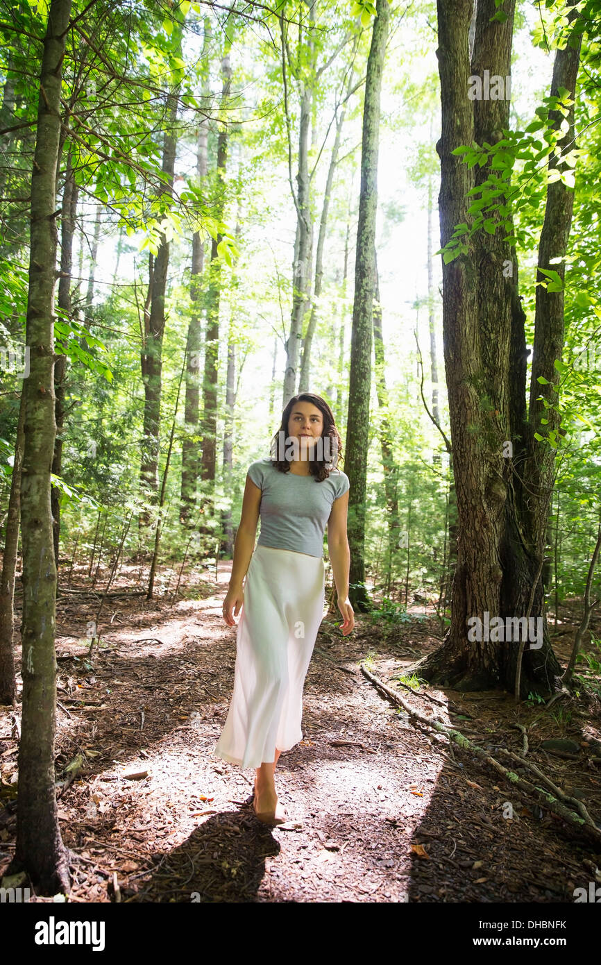 A young woman walking through woodland. Stock Photo