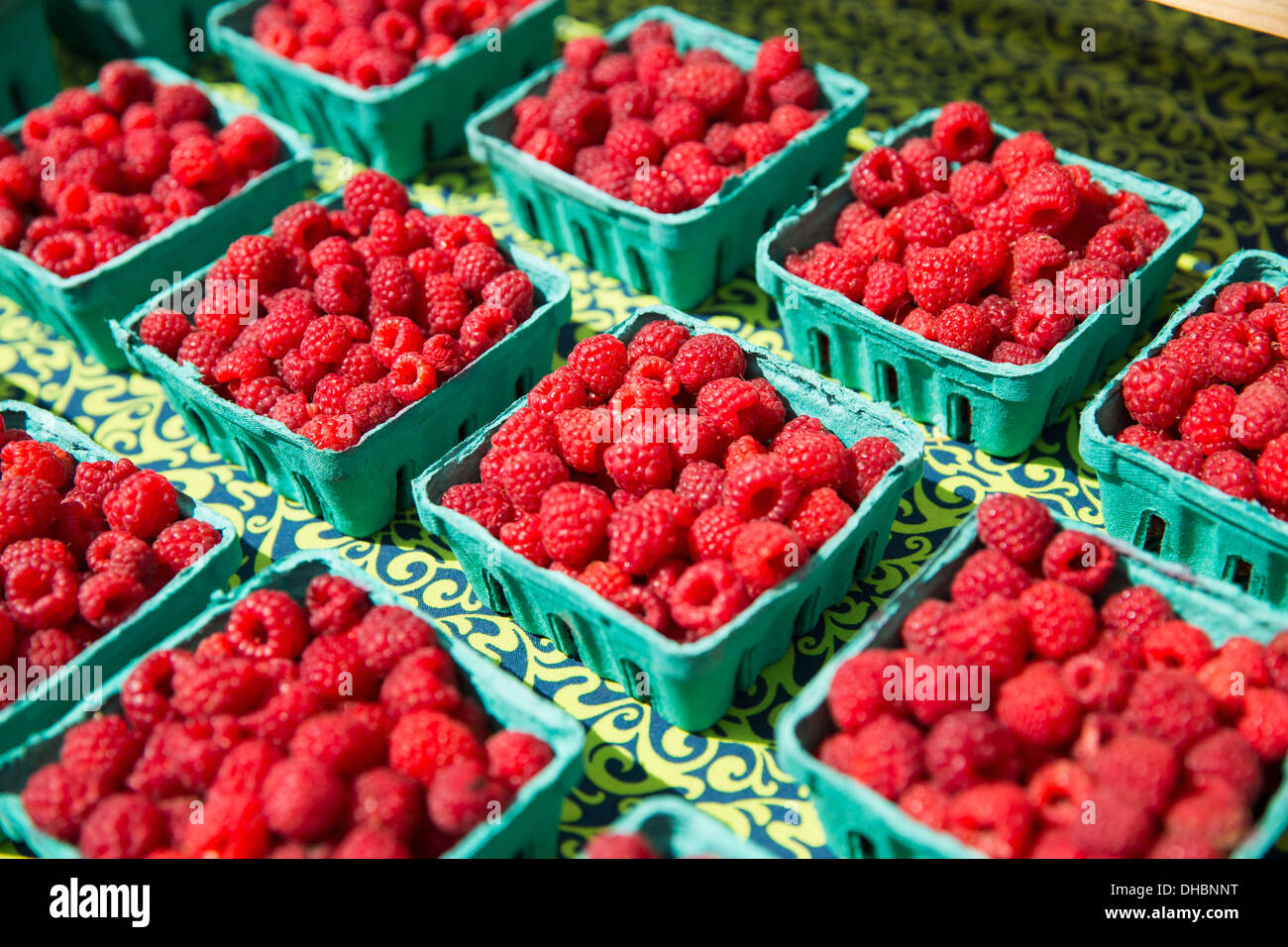 A farm stand, with displays of punnets of fresh berry fruits. Raspberries Stock Photo