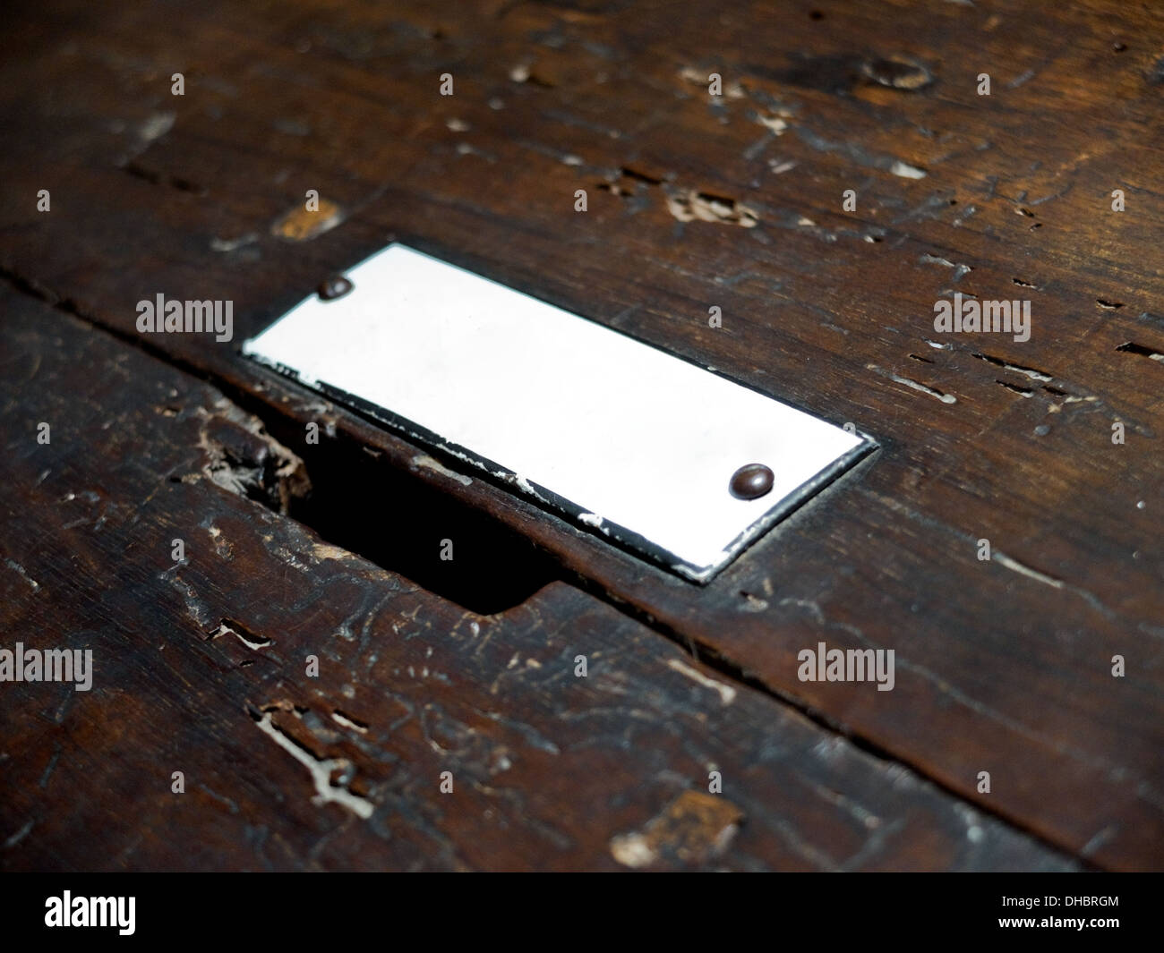 Blank plaque on a wooden surface with a hole of charity. Stock Photo