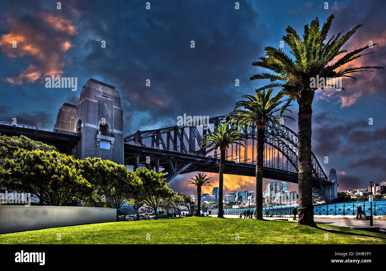 A black and white and color photograph of Sydney harbor bridge in Australia against a dramatic sky Stock Photo