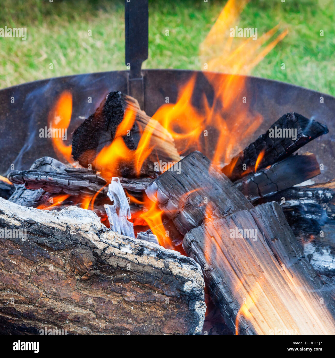 Logs burning in an outdoors fireplace Stock Photo