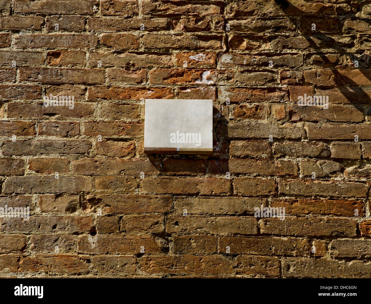 Marble blank plaque on a brick wall surface. Stock Photo