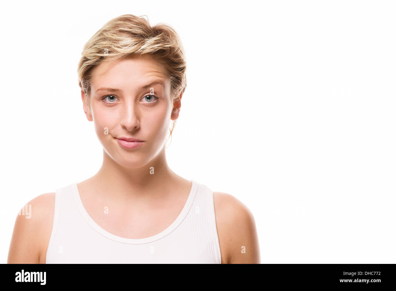 young blonde woman lifting eyebrow on white background Stock Photo