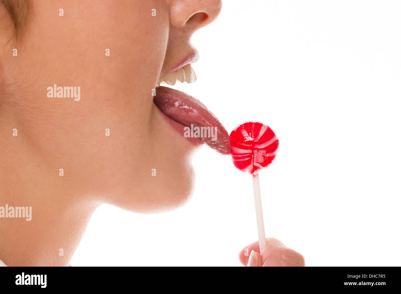 closeup tongue licking lollipop on white background Stock Photo
