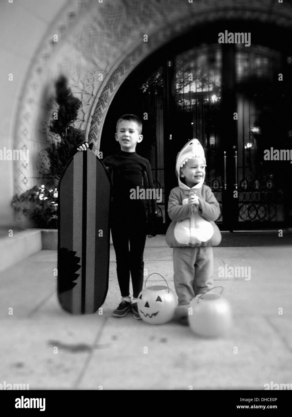 Two Young Boys in Halloween Costumes Standing in front of Building Stock Photo