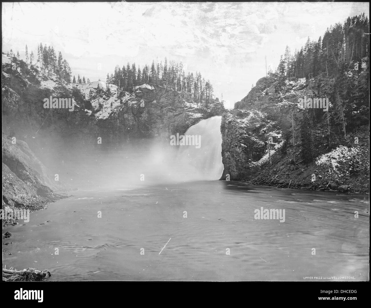 Upper Falls of the Yellowstone, located in Yellowstone National Park, Wyoming, is a well-known natural landmark. The image showcases the dramatic waterfall and its surrounding landscape. Stock Photo