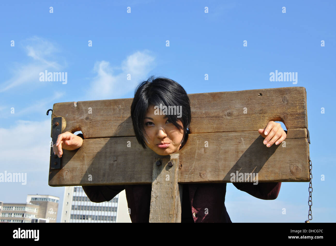 Japanese tourist with head in stocks in the grounds of Nottingham Castle, Nottingham, England, UK Stock Photo