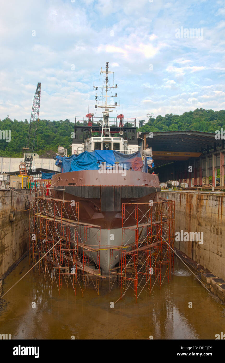 supply boat sand blasting and painting in progress during dry docking Stock Photo