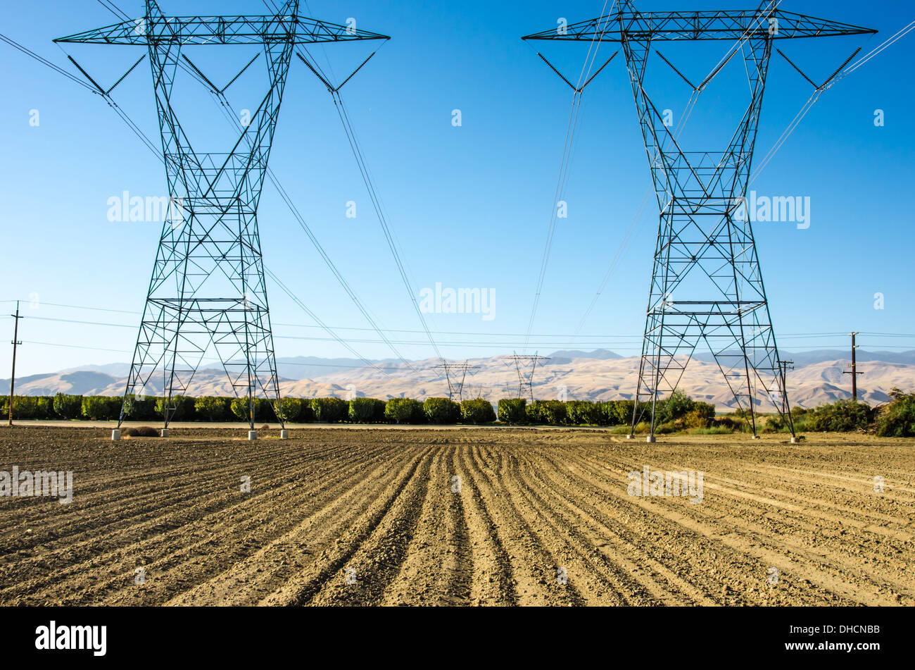 Electrical transmission towers in a field. Central California, United States. Stock Photo