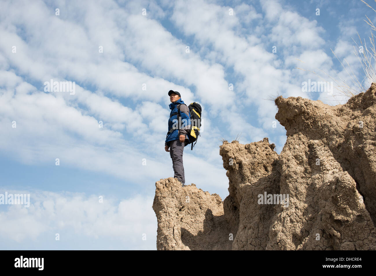 Hiker standing on a cliff overlooking. Asian Youth Stock Photo