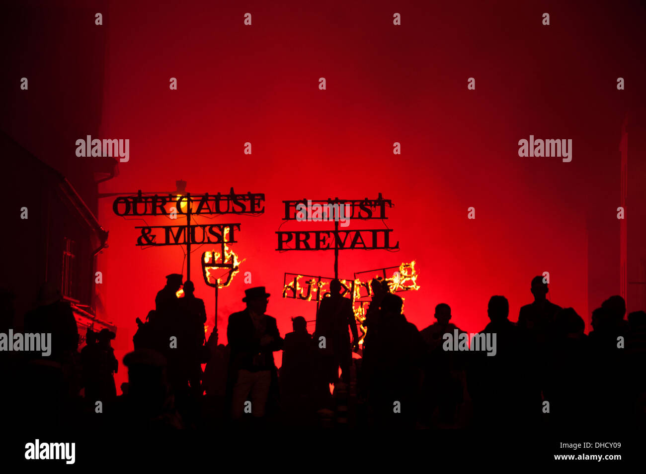 Lewes, Sussex. Bonfire Night November 5th 2013. Silhouetted revelers with signs saying 'Our cause is just and must prevail'. Stock Photo