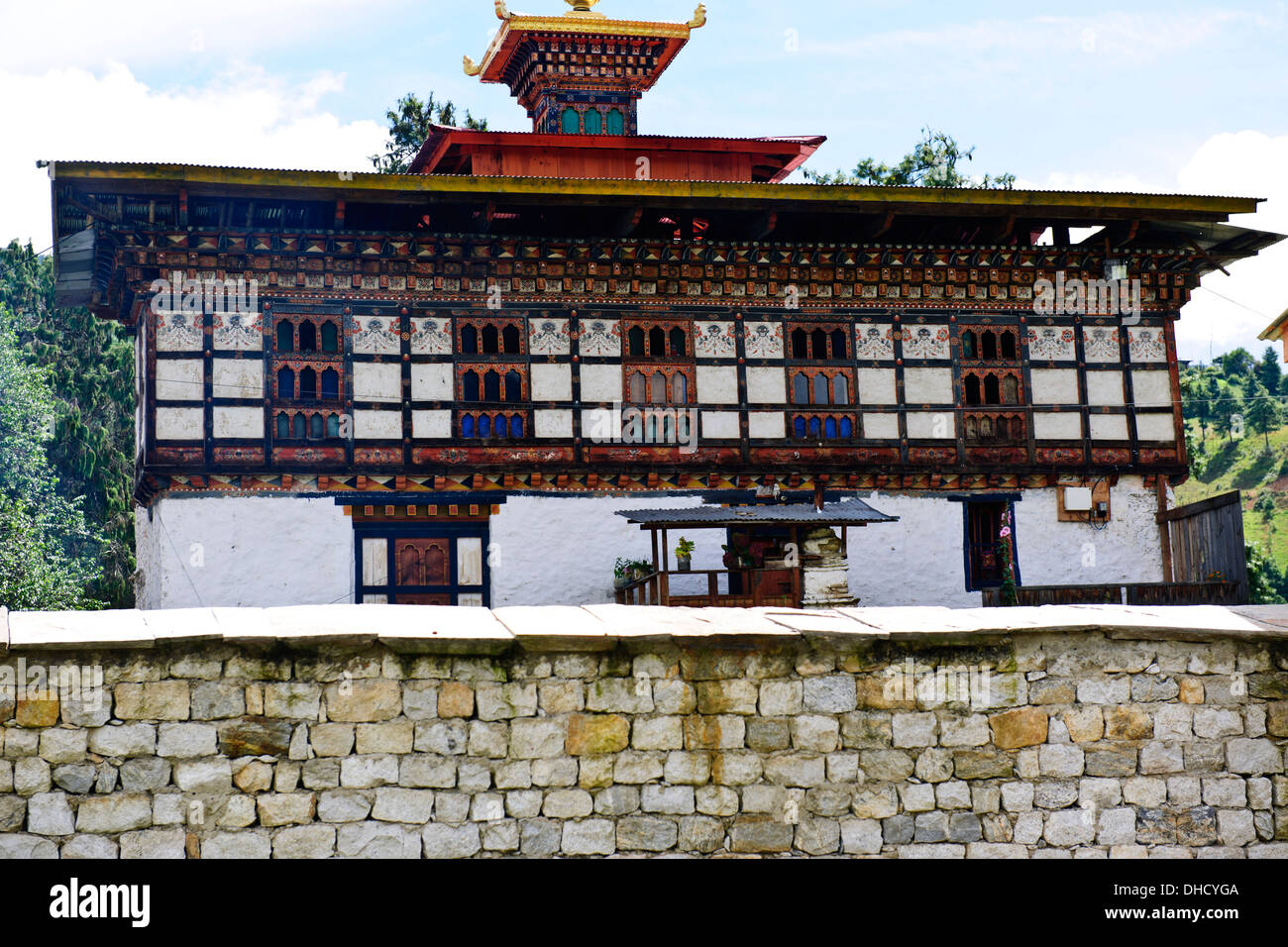 Traditional houses,wall paintings such as large red phallus symbols,animals by colorfully adorned wooden window frames,Bhutan Stock Photo