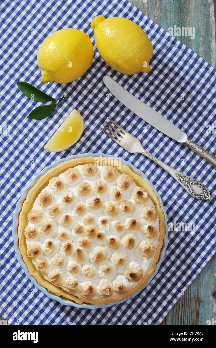 Lemon Meringue Pie with fresh lemons on checkered background Stock Photo