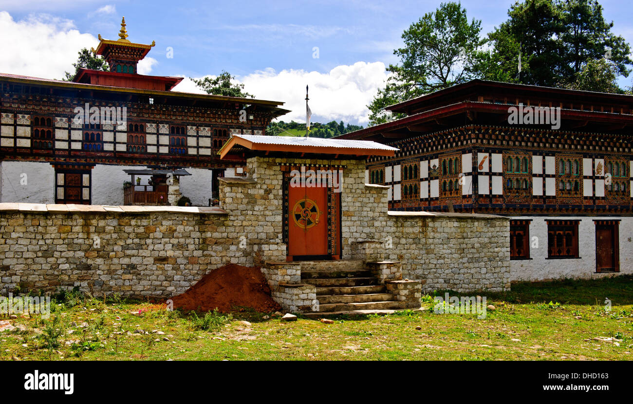 Traditional houses,wall paintings such as large red phallus symbols,animals by colorfully adorned wooden window frames,Bhutan Stock Photo